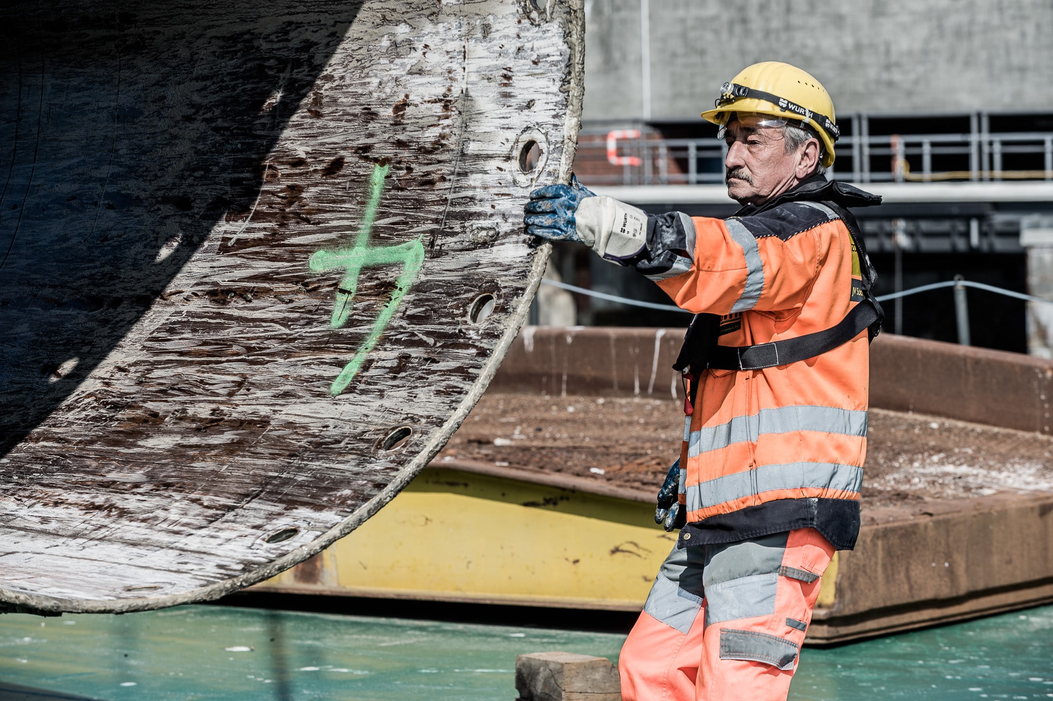 Arbeiter in Schutzkleidung und Helm mit Rohr