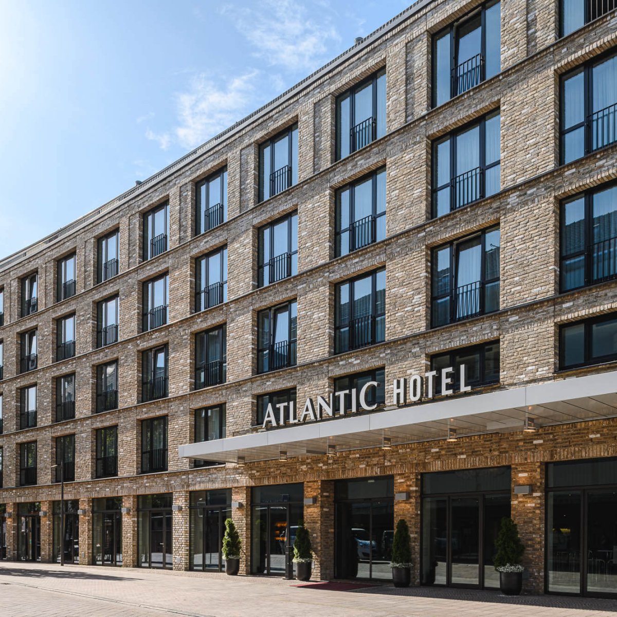 Außenansicht des Atlantic Hotels mit mehrstöckiger Backsteinfassade und Eingangsvordach