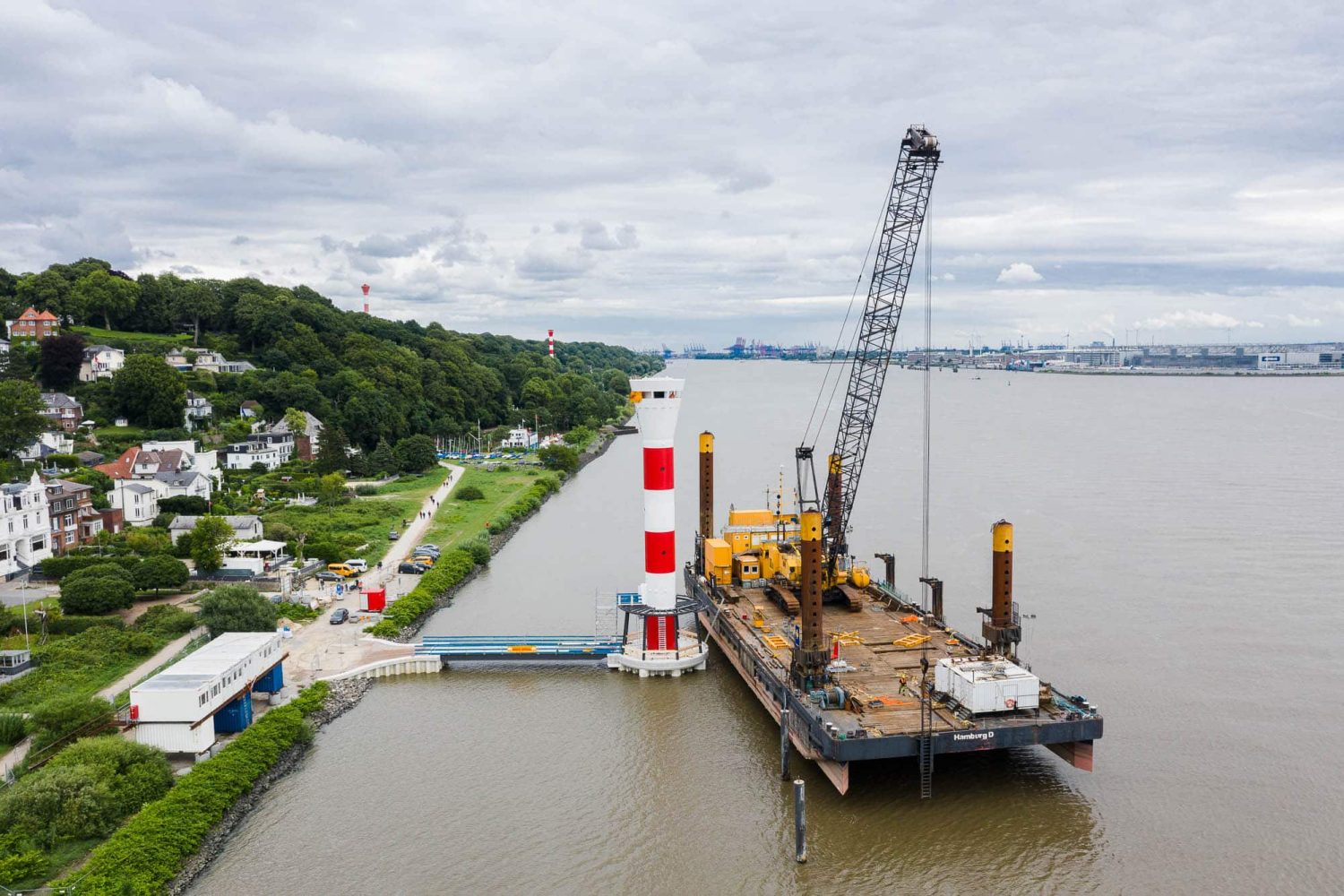 Luftaufnahme der Baustelle an der Richtfeuerlinie Blankenese mit Schwimmkran und Leuchtturm auf der Elbe.