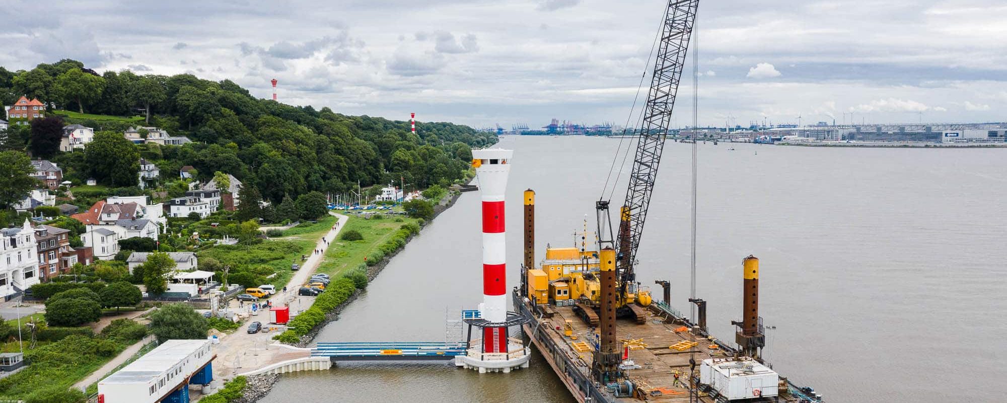 Luftaufnahme der Baustelle an der Richtfeuerlinie Blankenese mit Schwimmkran und Leuchtturm auf der Elbe.